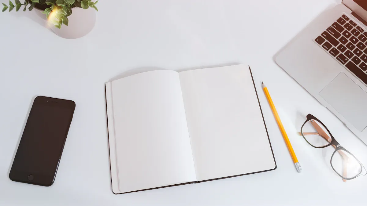 An open blank notebook beside a phone on a desk